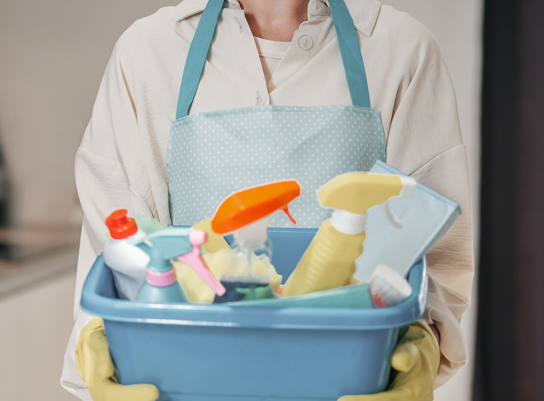 Professional cleaner organizing eco-friendly cleaning supplies